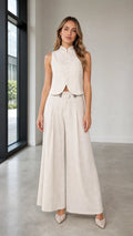 Front view of woman wearing beige sleeveless vest and wide-leg pants set