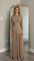 Front view of model wearing taupe long-sleeve maxi dress with corset waist