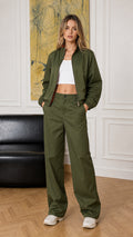 Full-body front view of woman wearing olive green bomber jacket and wide-leg pants set