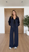 Front view of model wearing navy blue contrast collar zip jacket and wide leg pants set