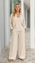 Front view of woman wearing beige 3-piece shirt and wide-leg pant set