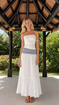 Front view of woman wearing white strapless smocked waist tiered maxi dress