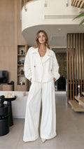 Front view of a woman wearing the white cropped blazer and wide-leg pants set