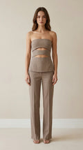 Front view of model wearing taupe strapless cut-out top and trousers set