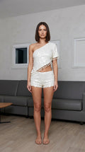 Model wearing white one-shoulder sequin crop top and shorts set, front view