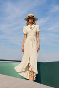 Front view of woman wearing cream polka dot maxi dress with hat
