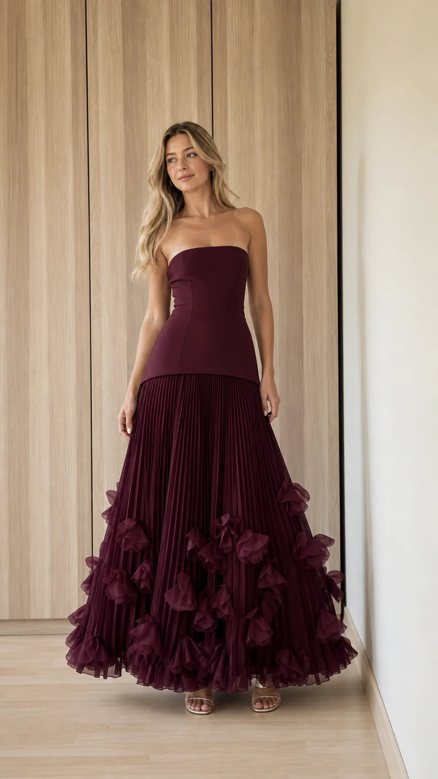 Front view of woman wearing burgundy strapless pleated ruffle evening gown