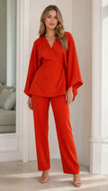 Front view of model wearing burnt orange wrap top and straight-leg pant set