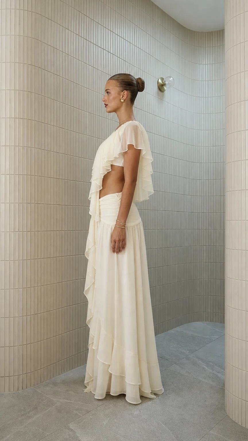 Side profile view of ivory ruffled crop top and maxi skirt