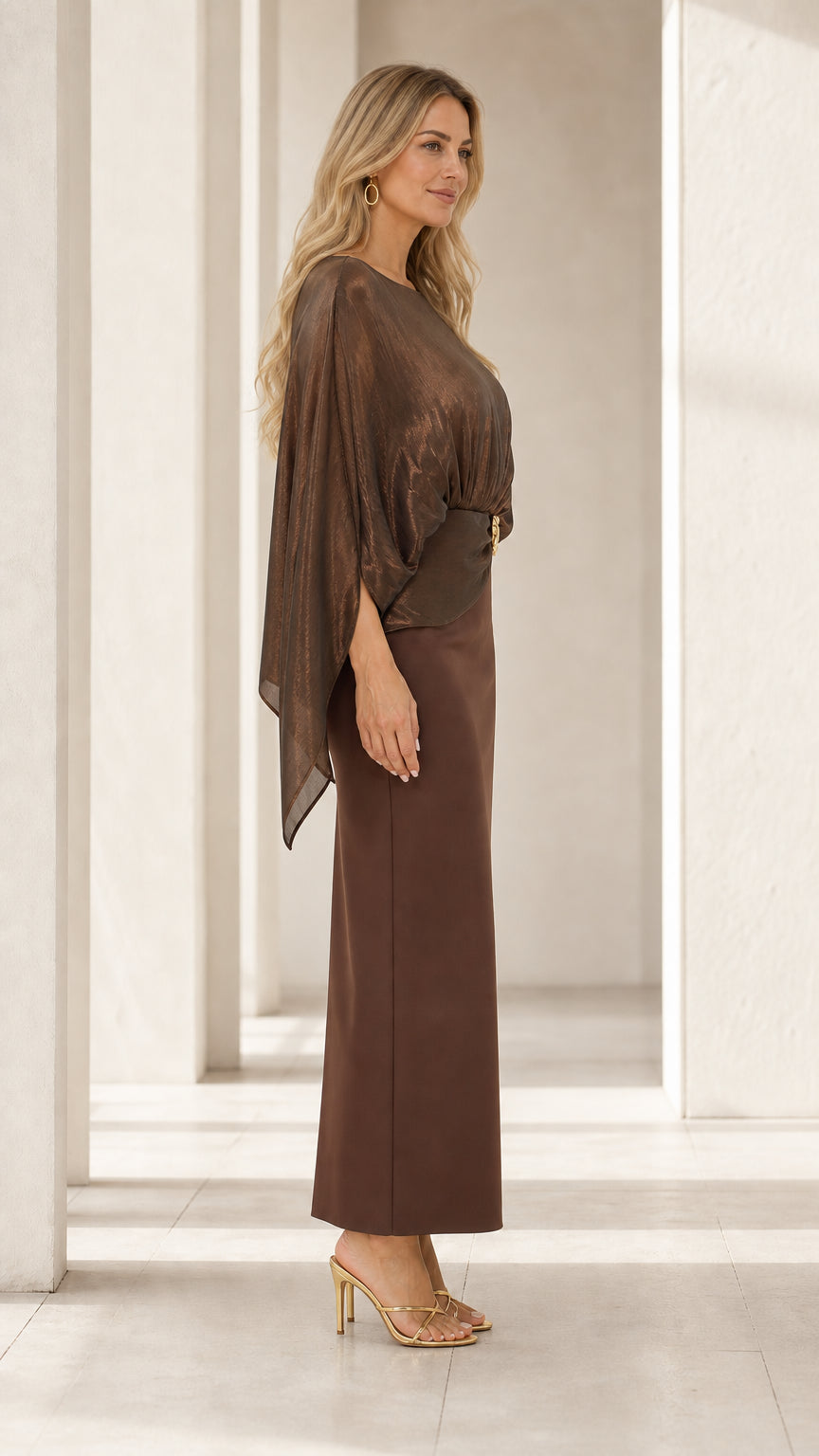 Side profile of woman wearing bronze brown cape overlay column evening gown