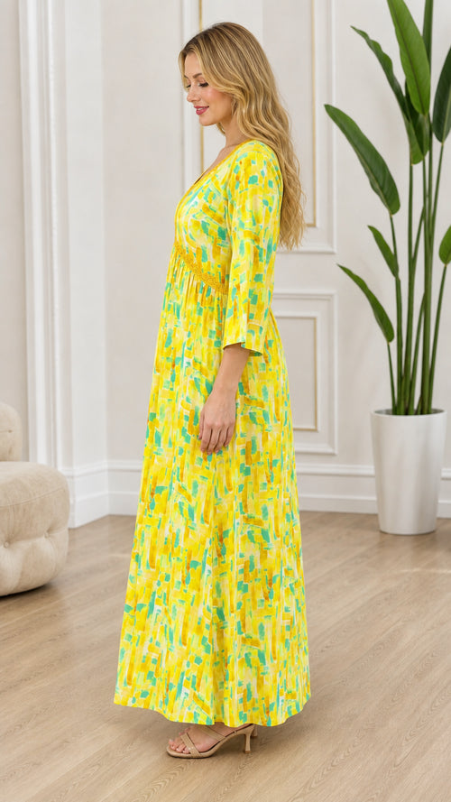 Side profile view of yellow abstract print maxi dress showing flowy silhouette and 3/4 sleeves