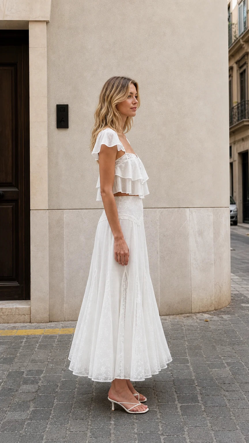 Side view of woman wearing white ruffled two-piece maxi set