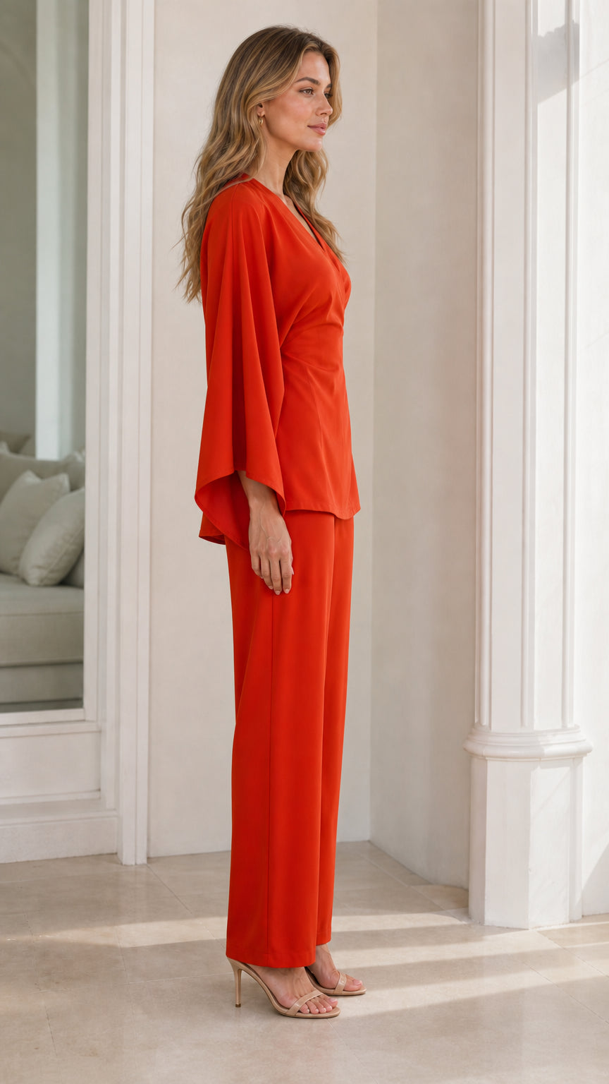Side angle view of model wearing burnt orange draped sleeve pant set
