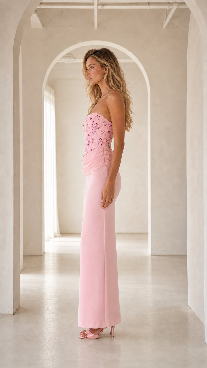 Side profile view of pink strapless corset formal maxi dress
