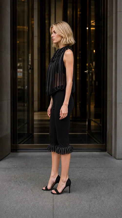 Side profile of model wearing black pleated fringe two-piece set