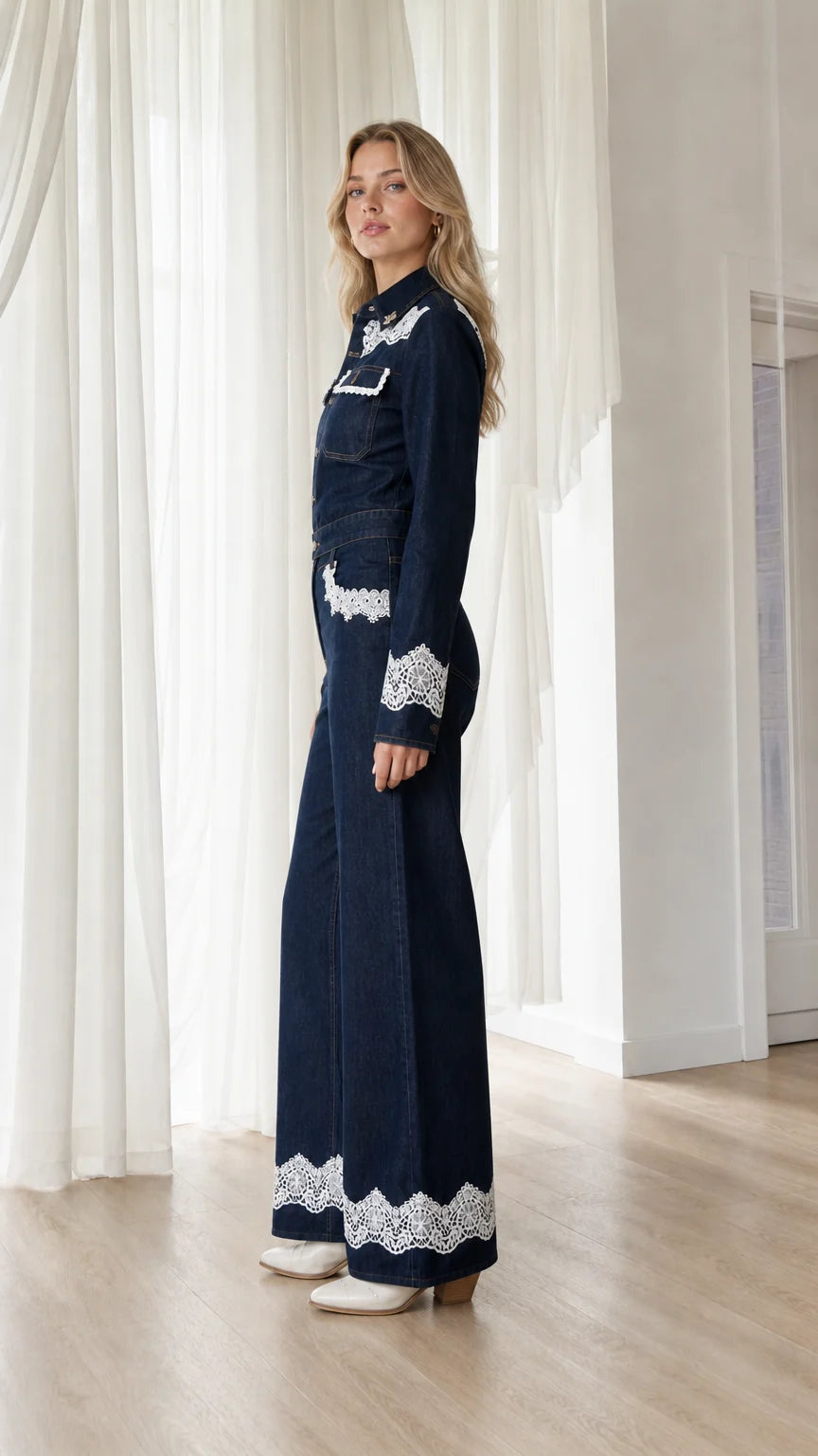Side profile view of dark denim jumpsuit with wide leg
