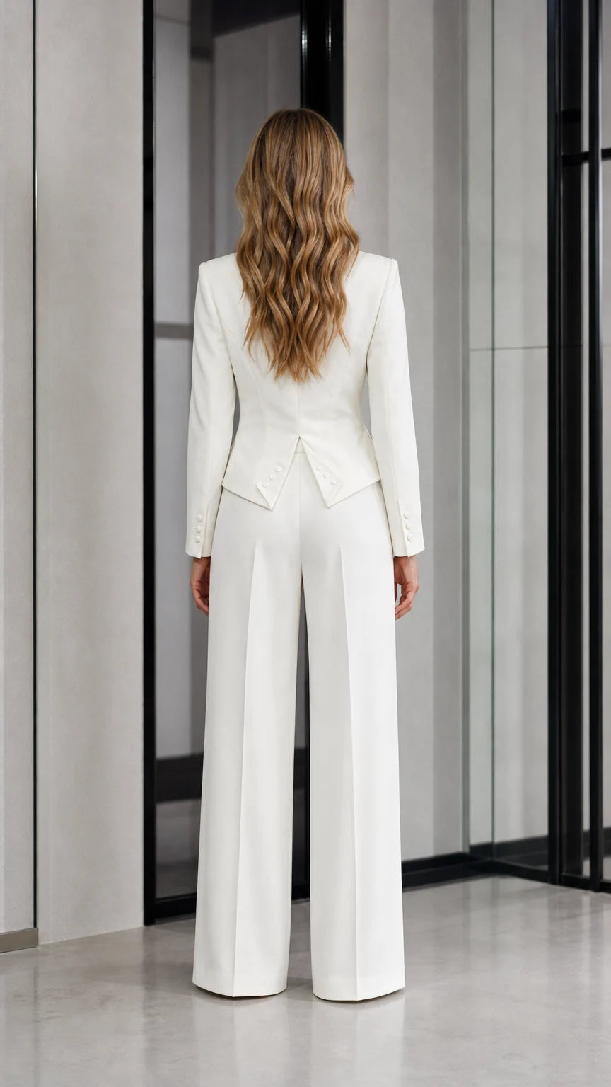 Back view of woman wearing white tailored suit set with flared hem detail