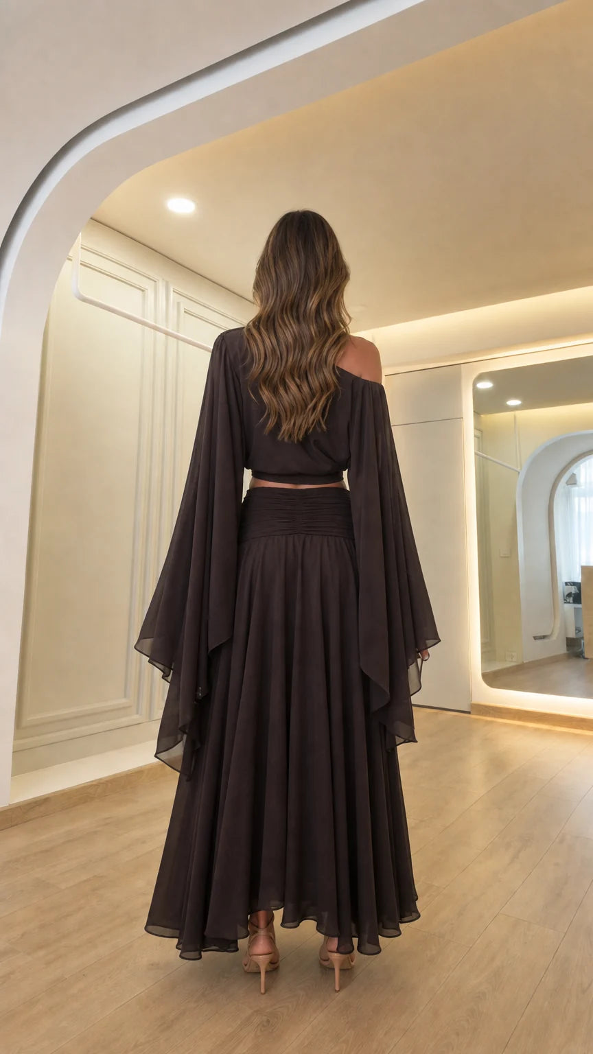Back view of woman showcasing the draped back design of the dark brown outfit