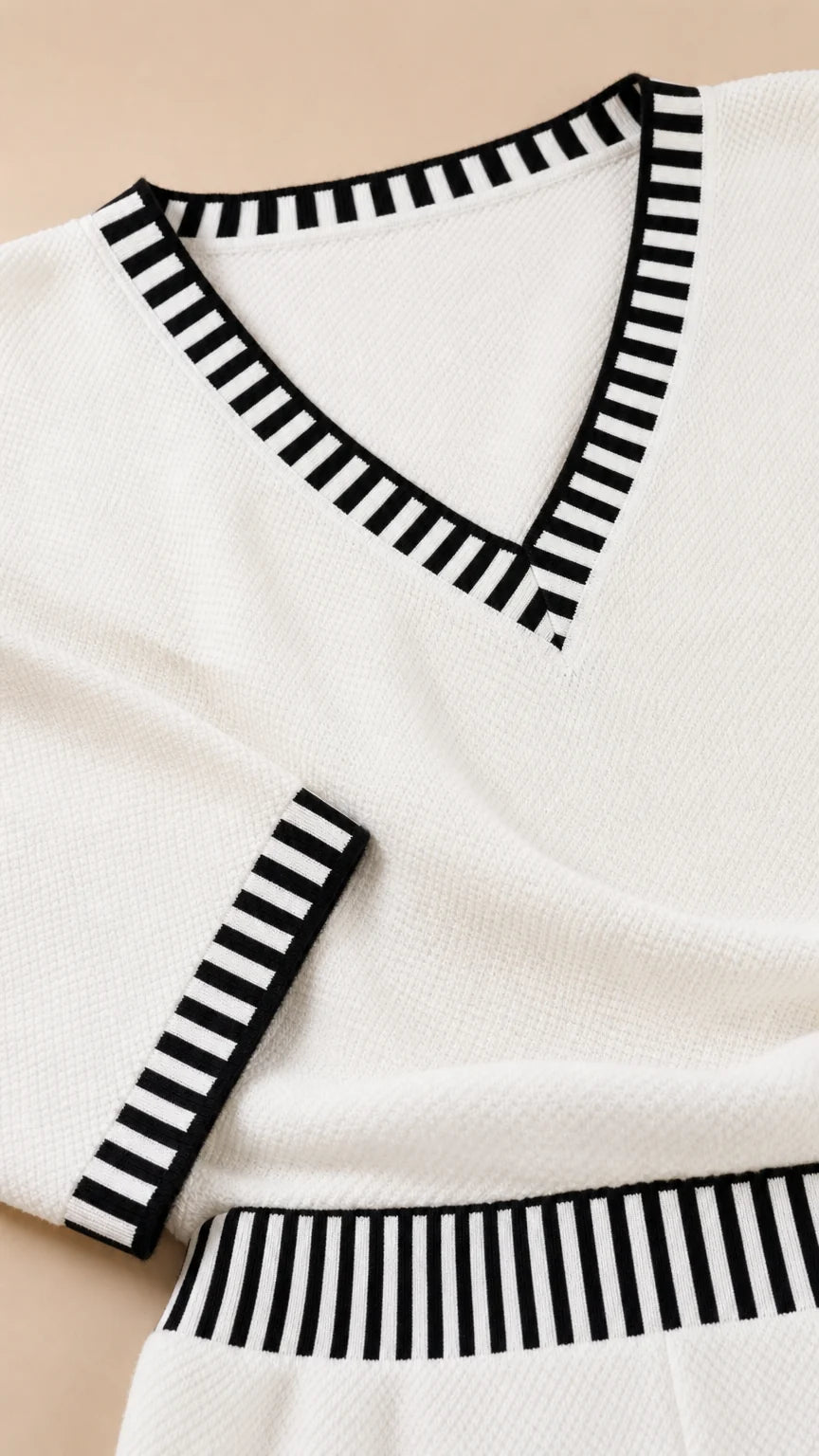 Close up detail of black and white striped trim on V-neck collar and cuffs
