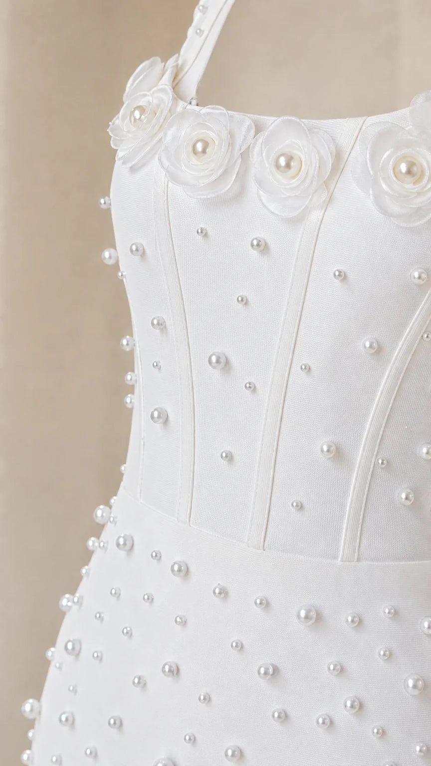 Close up of 3D rosette and pearl bodice details on white dress