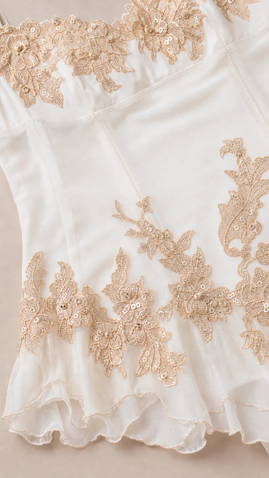 Close up of gold embroidery and sheer hem details