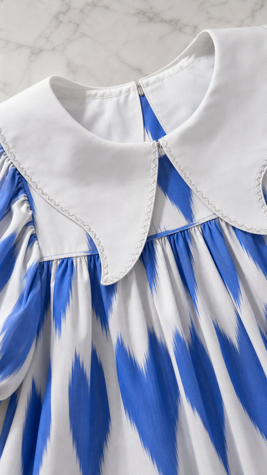 Close-up of white pointed contrast collar and neckline on printed tunic