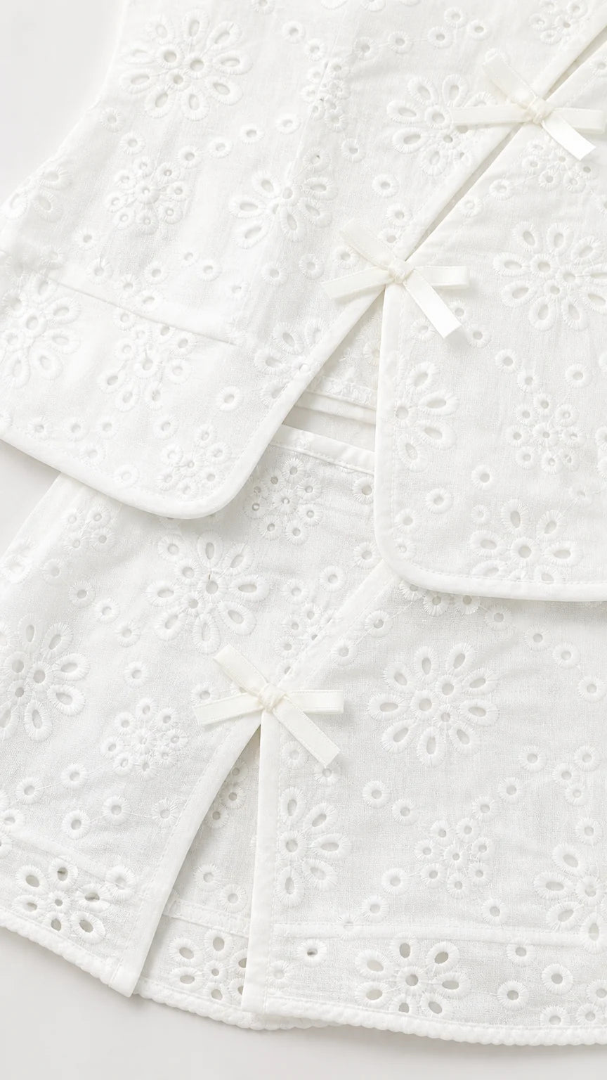 Close-up of white eyelet fabric and bow details