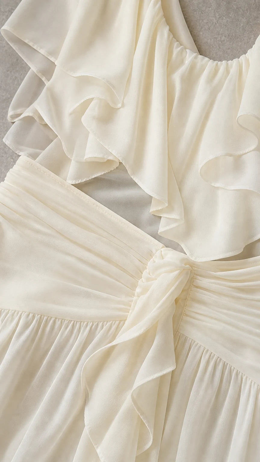 Close-up detail of the ruffled neckline and knotted waist