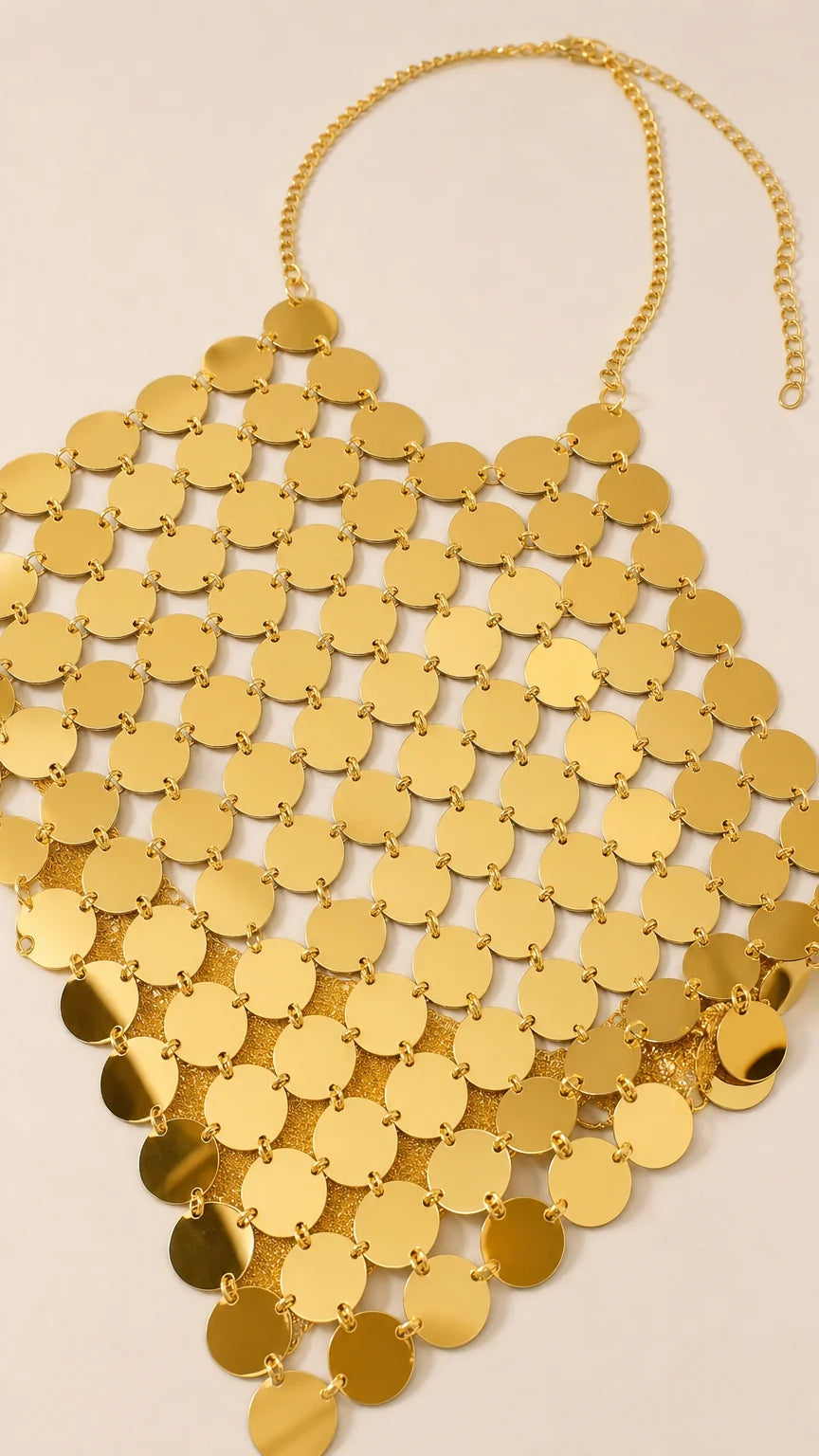 Close-up flat lay of the gold metallic disc halter top
