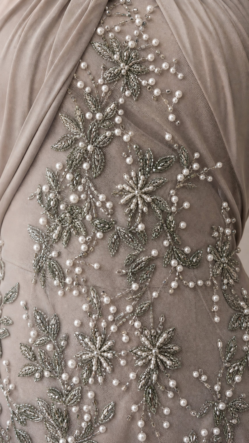 Close-up detail of delicate pearl and silver bead floral embroidery on mesh fabric