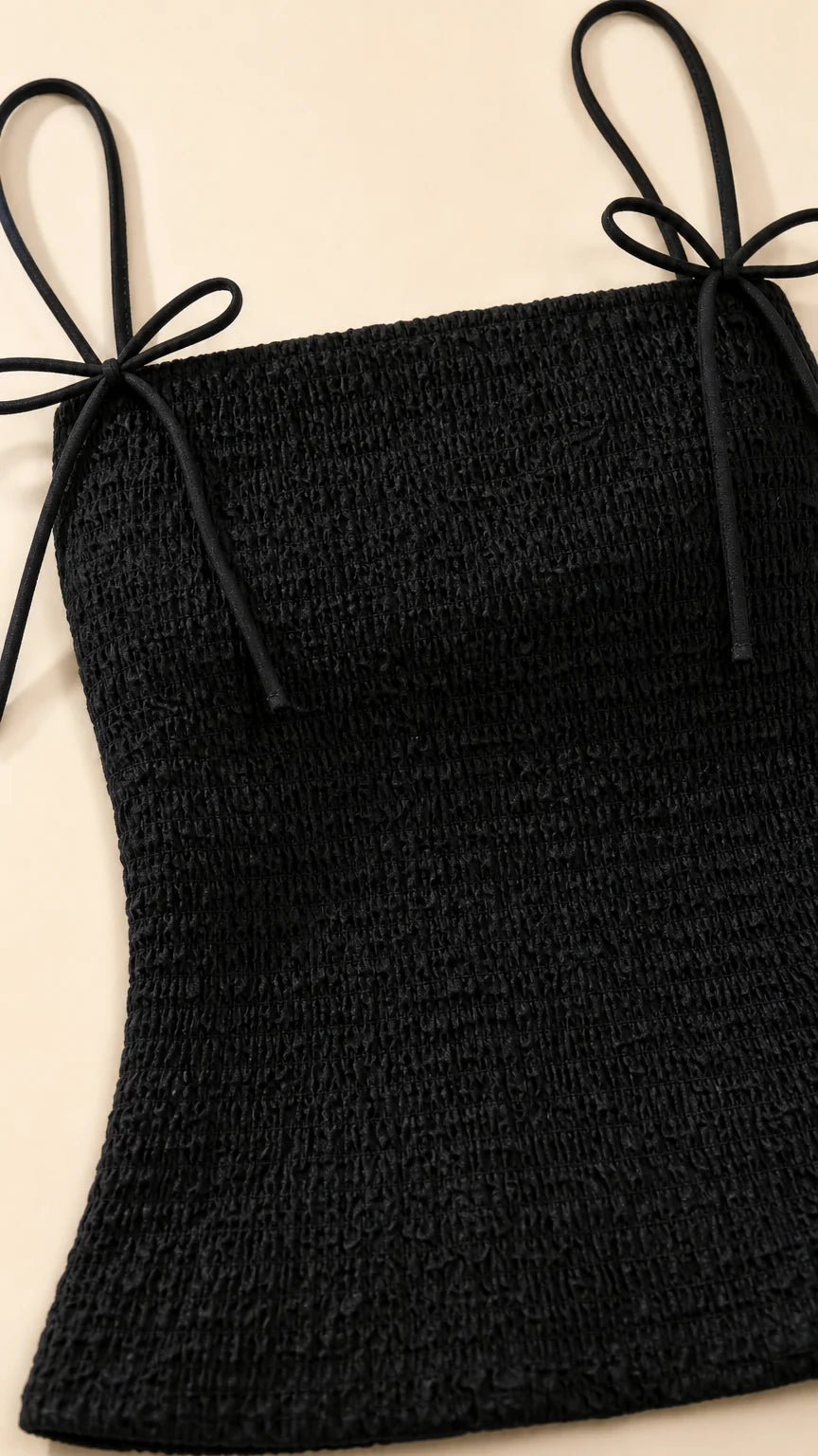 Close-up of black smocked top with tie straps