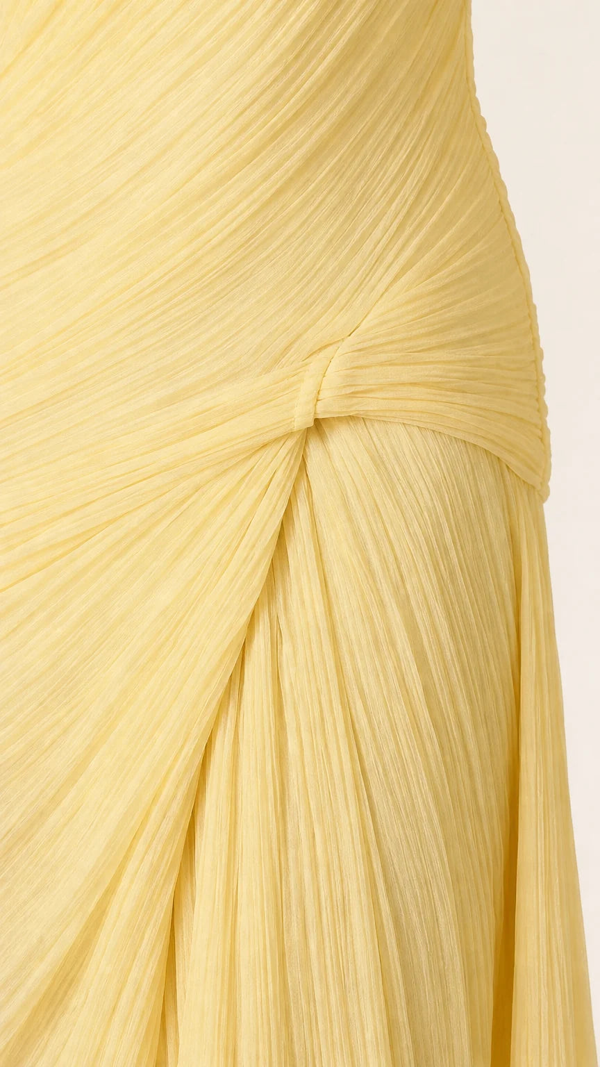 Close-up detail of pleated texture and side knot on yellow maxi dress