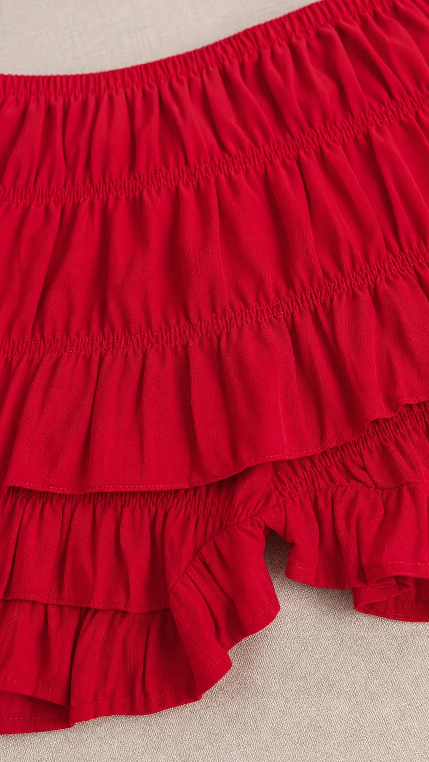 Close-up of the red crinkled fabric and layered ruffle shorts
