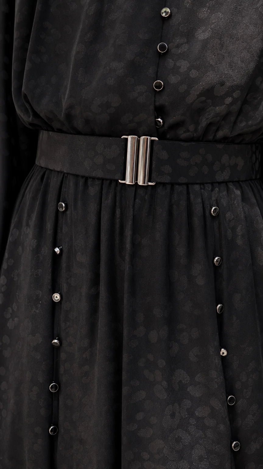 Close-up of black dress belt and button details