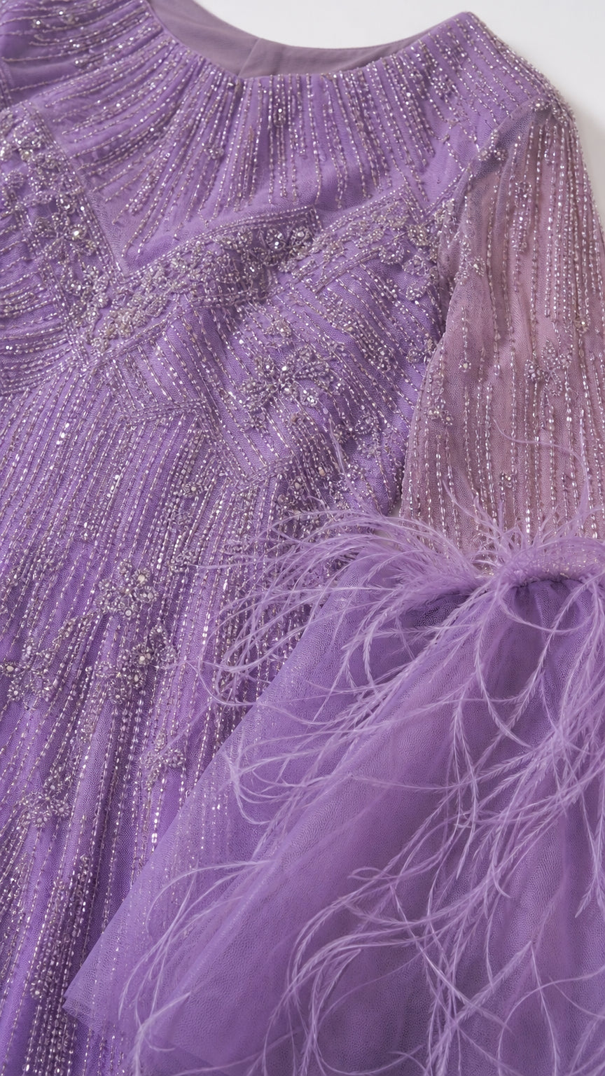 Close-up detail of lavender neckline and sleeve showing intricate beadwork and feather embellishment