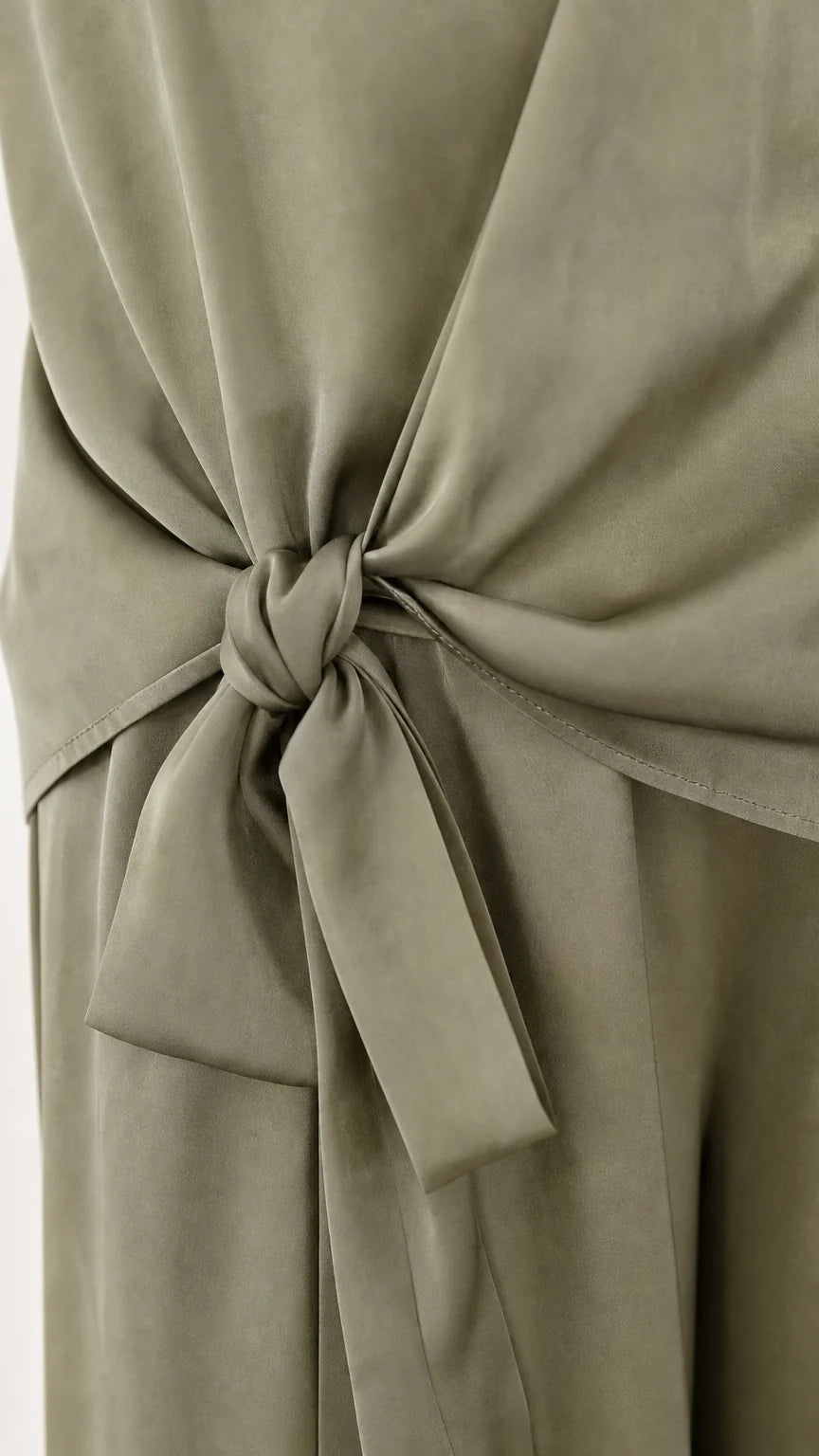 Close up of side tie detail on sage green satin pants