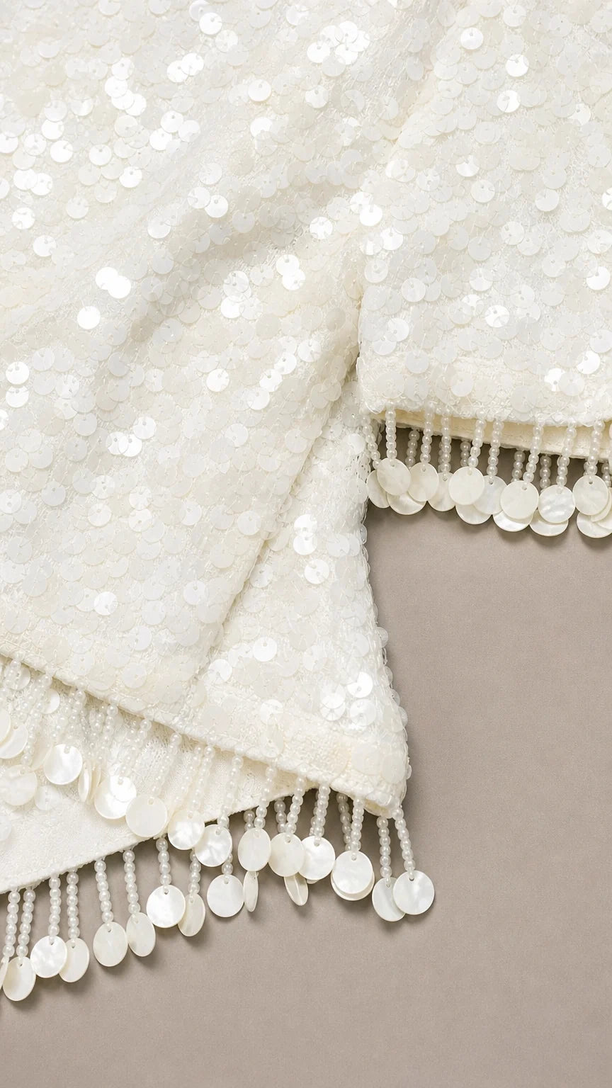 Close-up of white sequin fabric and fringe trim