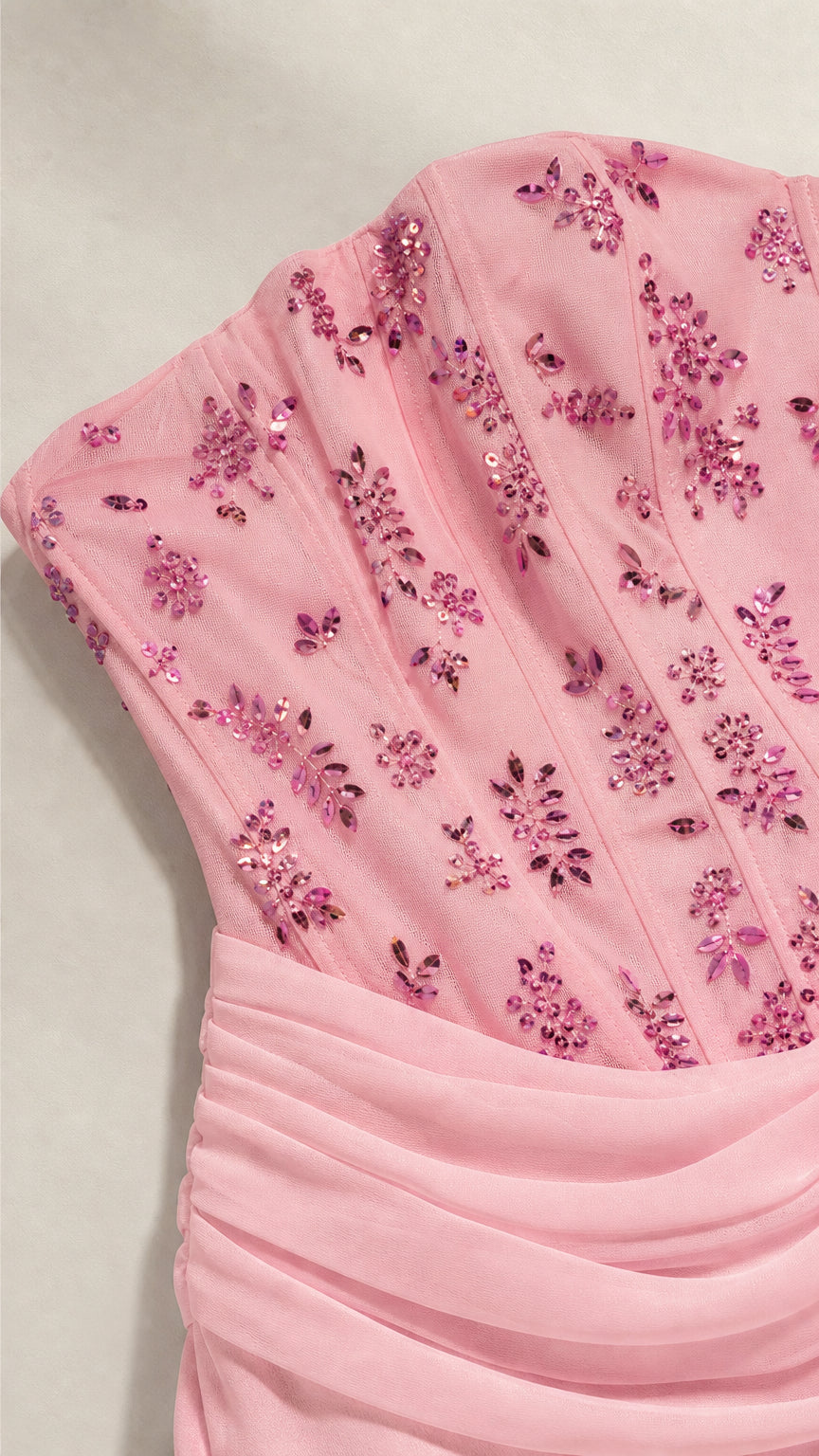 Close-up of pink beaded corset bodice with floral sequin embroidery and draped waistband