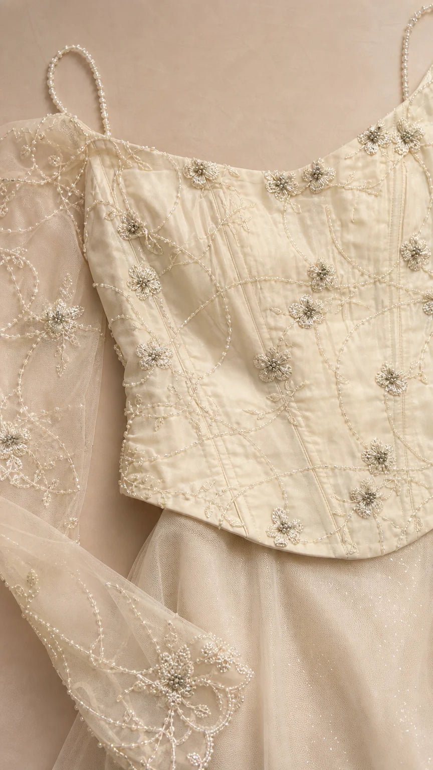 Close-up detail of beaded bodice and sheer sleeves