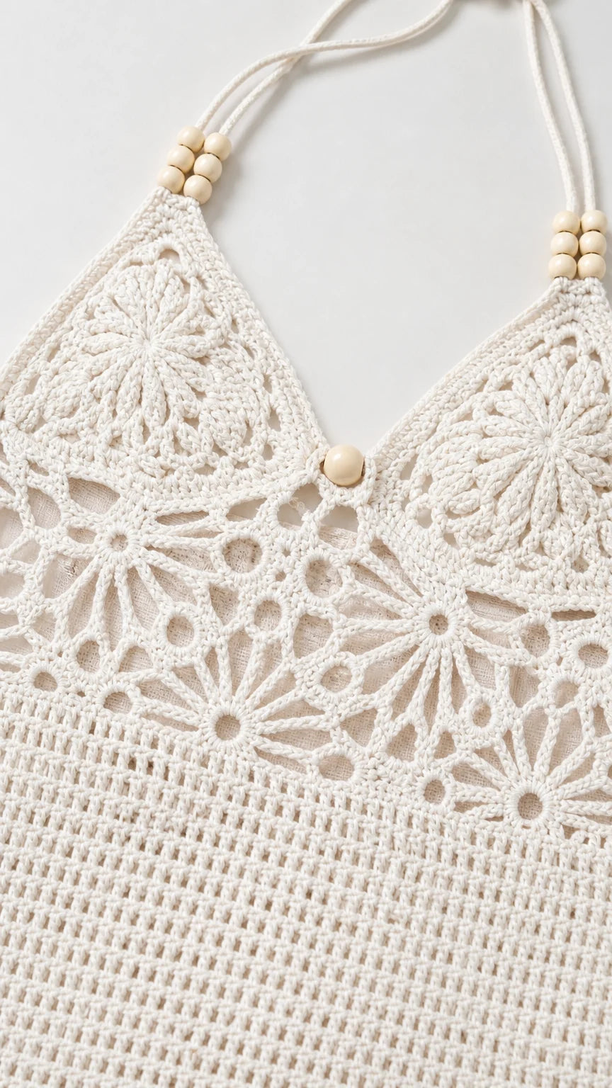 Close-up detail of white crochet halter neckline with wooden beads