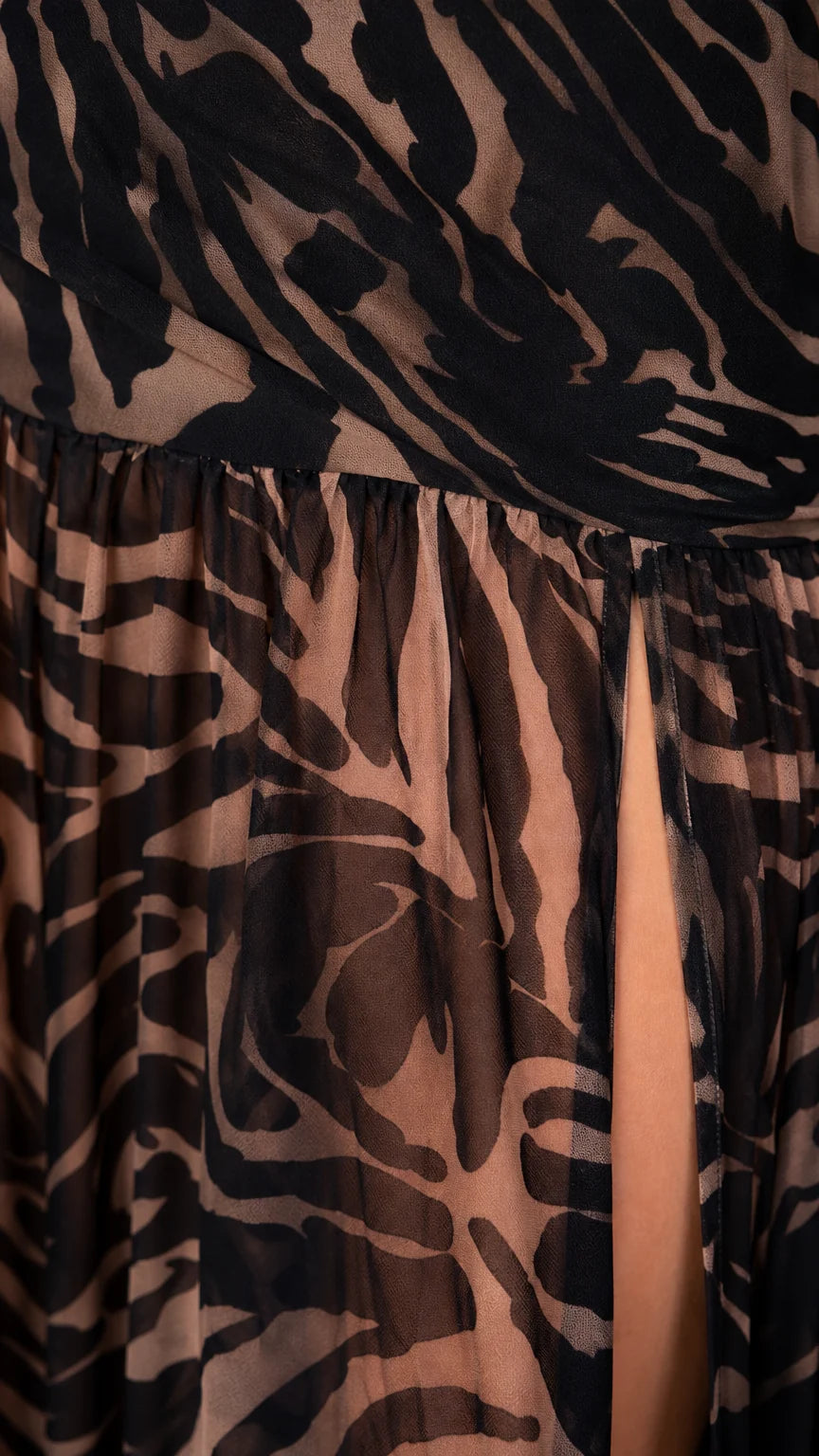 Close-up detail of fabric texture and high slit on zebra print maxi dress