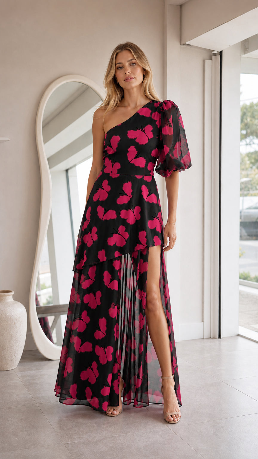 Front view of model in black butterfly print one-shoulder maxi dress with puff sleeve and slit