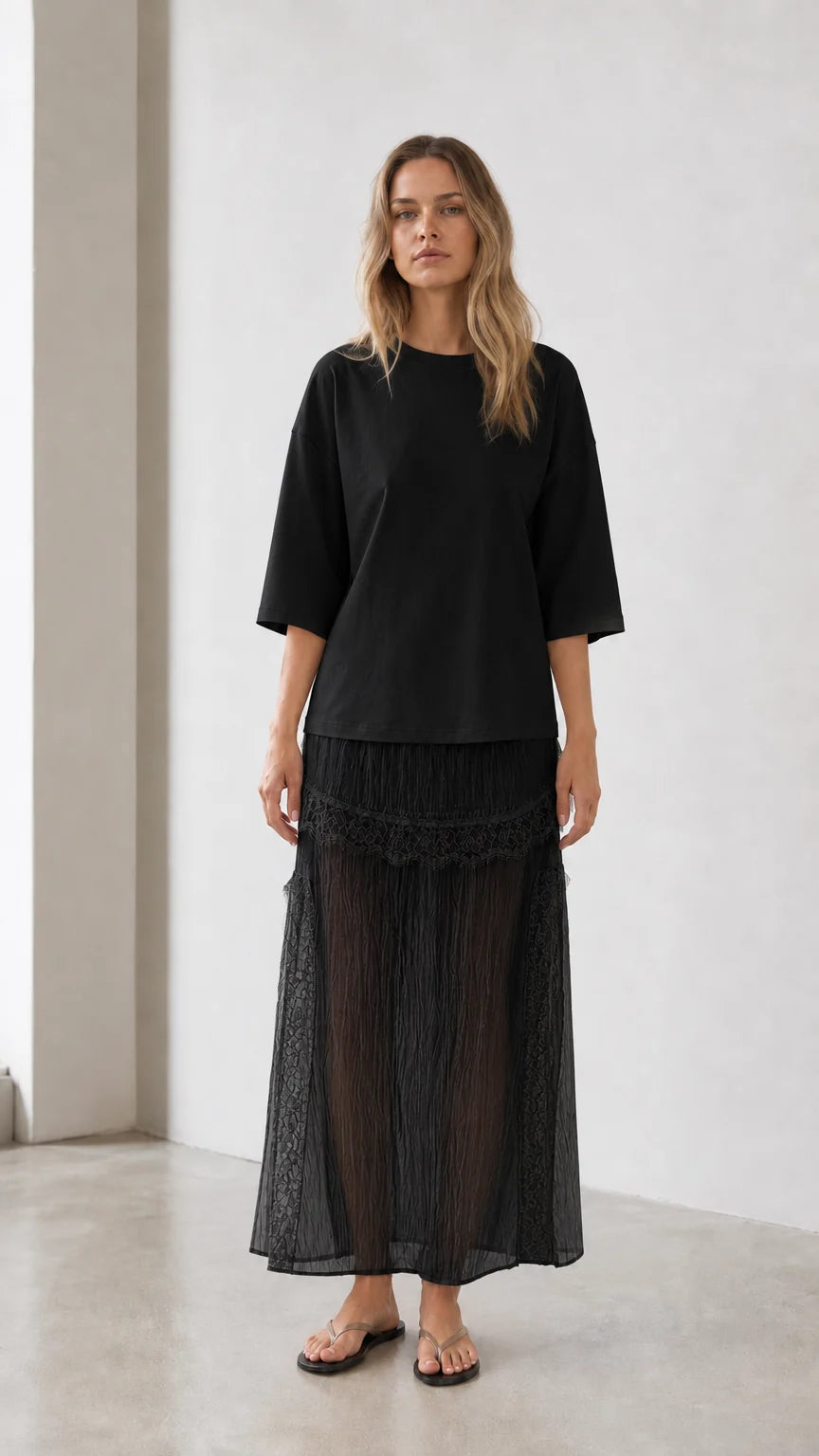 Front view of woman wearing black relaxed tee and matching skirt set