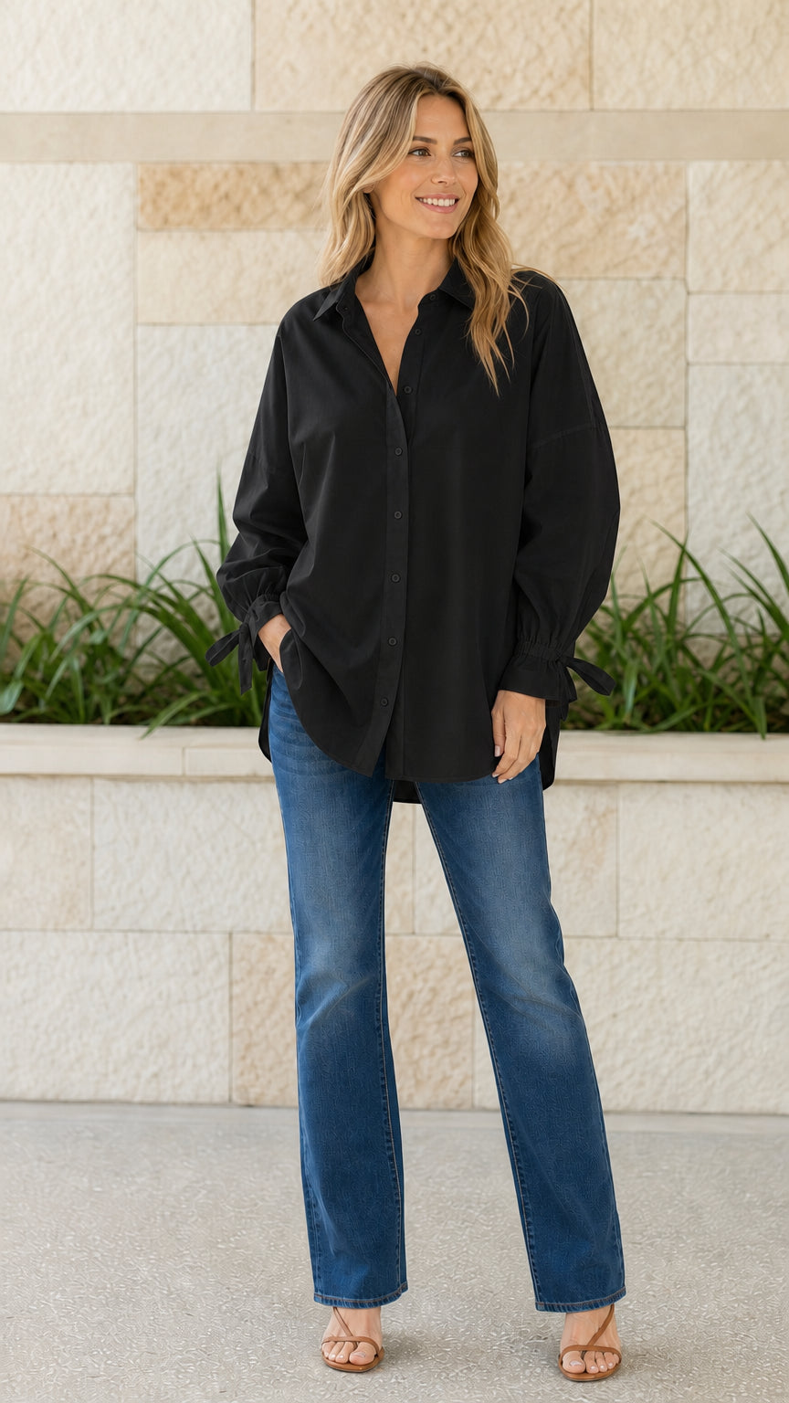 Woman wearing black oversized button-down shirt with tie cuffs