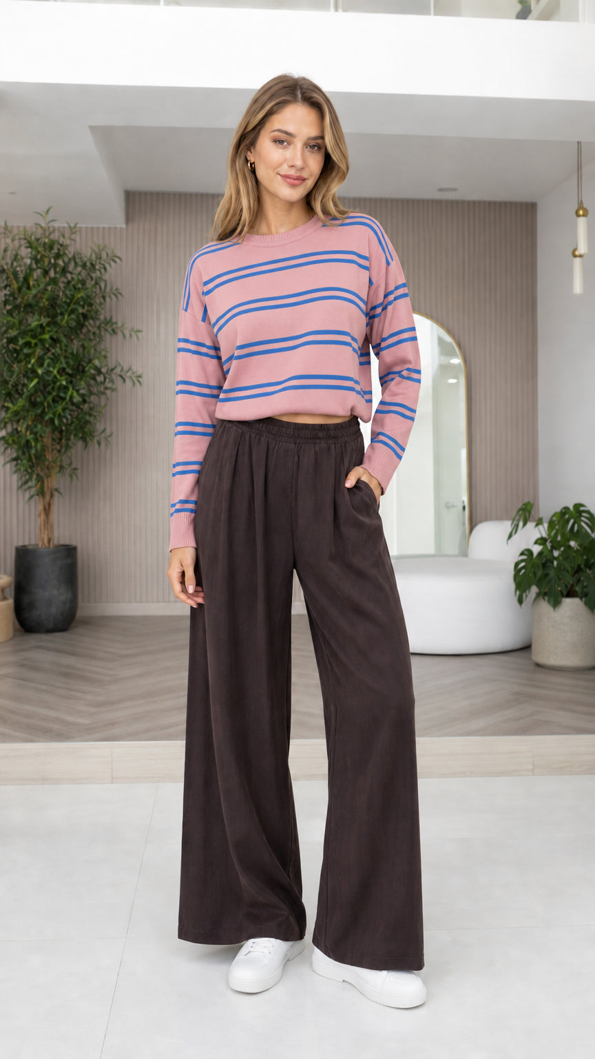 Model wearing light pink and blue striped cropped sweater with dark wide-leg pants