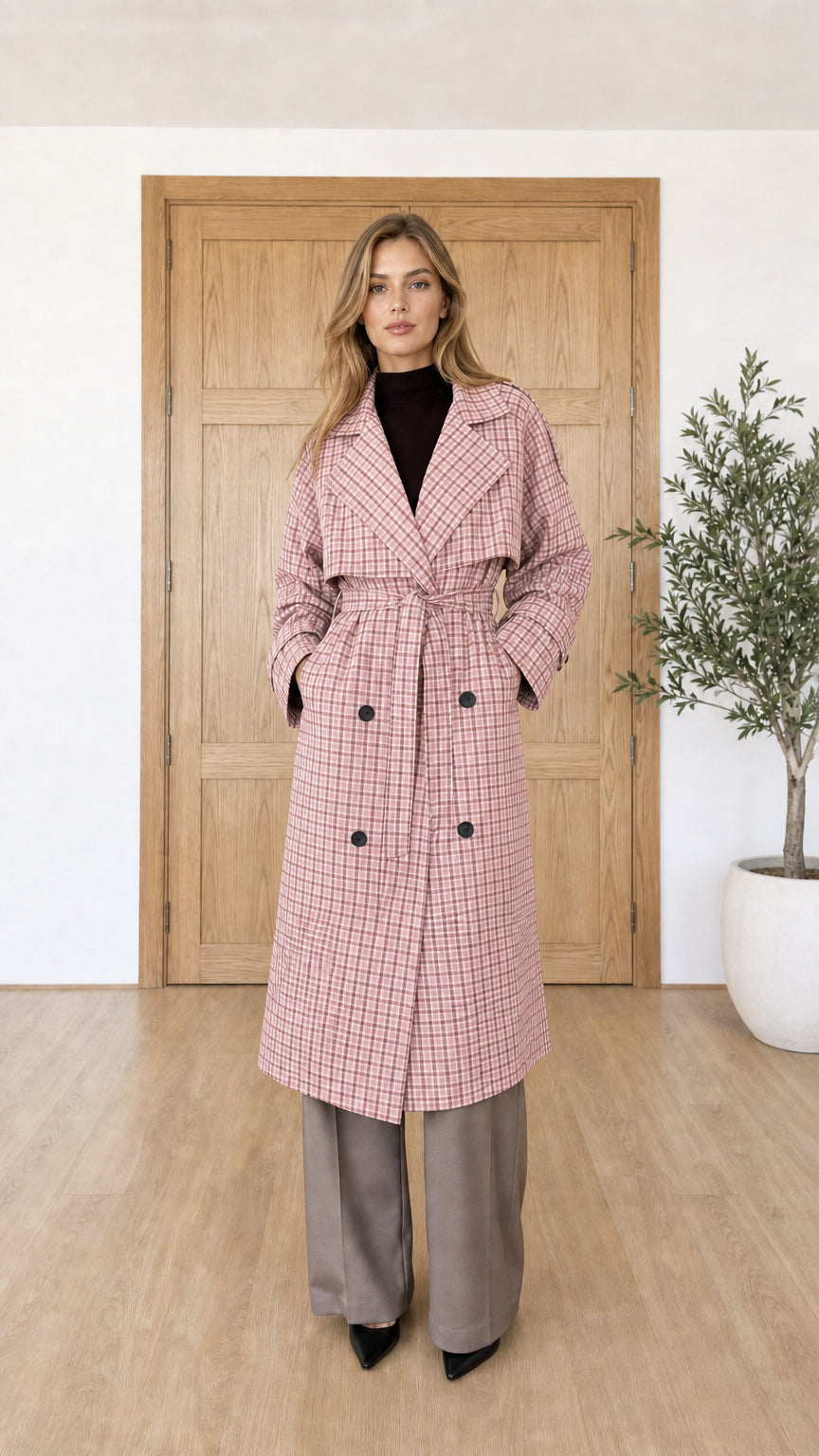 Woman wearing pink plaid trench coat with double-breasted buttons