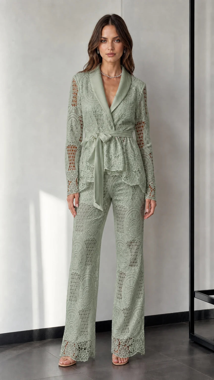 Woman wearing sage green lace blazer and trousers set