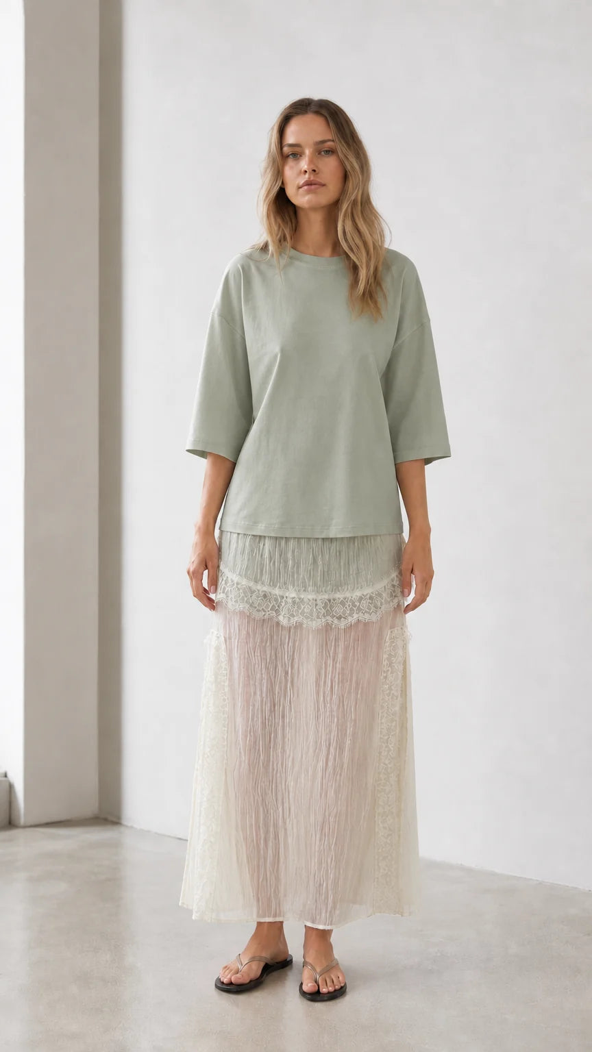 Front view of woman wearing sage green relaxed tee and matching skirt set