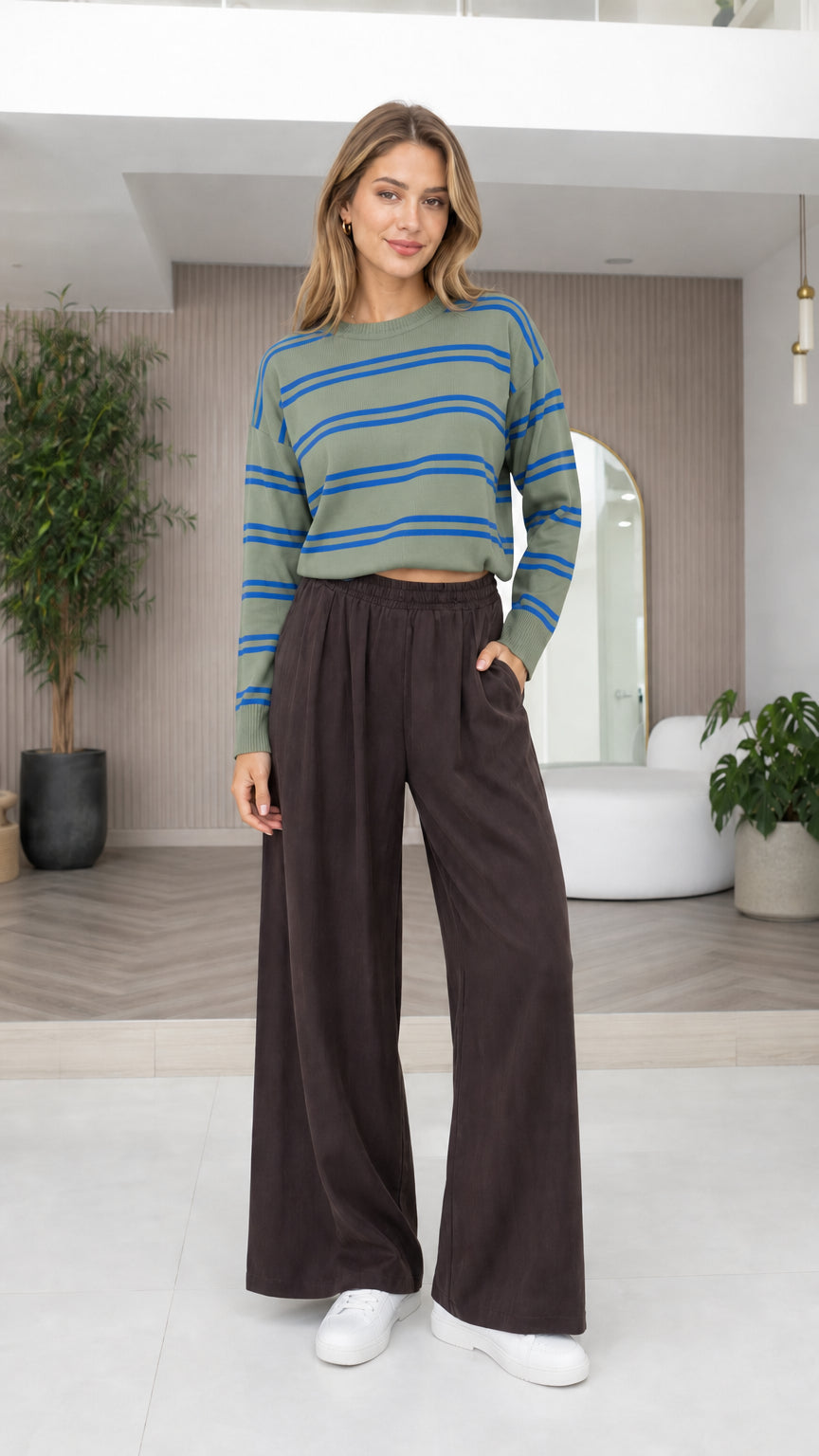 Model wearing sage green and blue striped knit pullover with wide-leg trousers