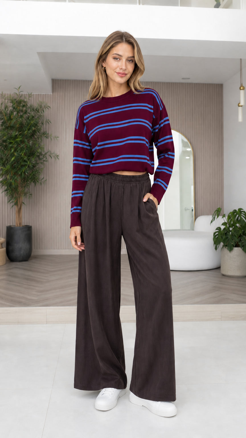 Model wearing burgundy and blue striped crewneck knit top with wide-leg pants
